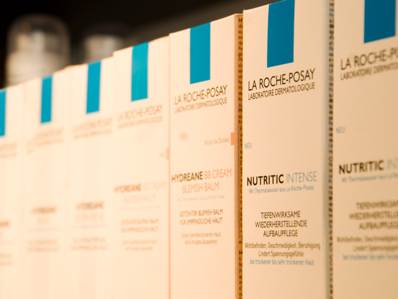 Reihe von La Roche-Posay Kosmetikverpackungen im Regal, sorgfältig sortiert und gleichmäßig ausgerichtet.